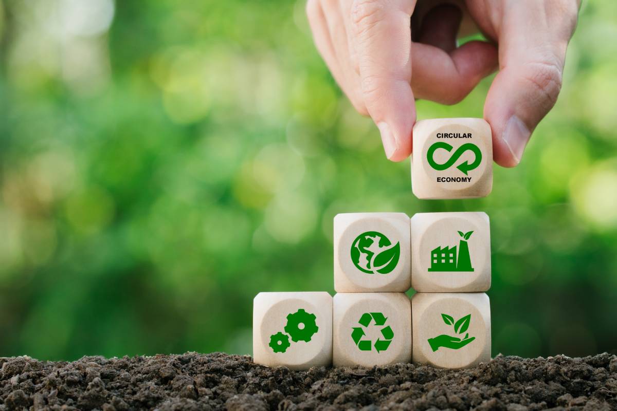 Circular economy concept.Hand holding wooden block with green bokeh background.Eternity, endless and unlimited of Future business growth.Environmental sustainability and reduce pollution.