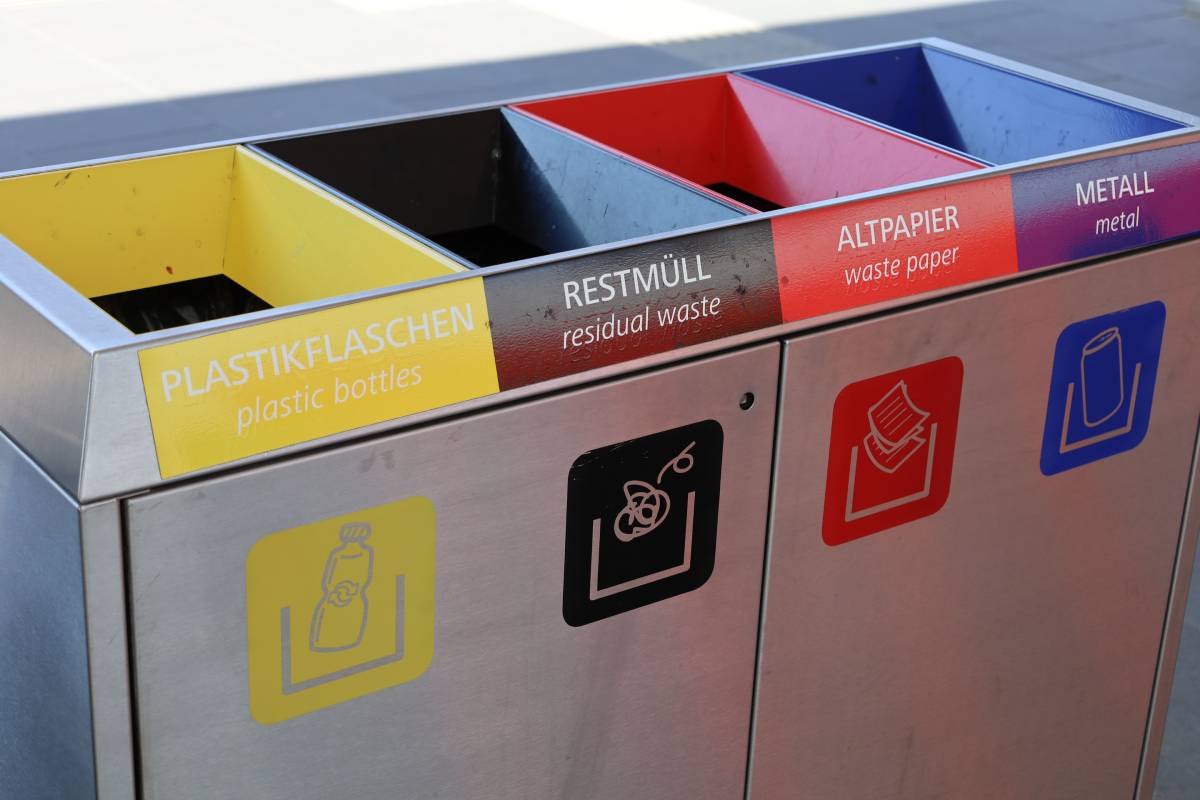 Closeup of an Austrian public recycle bin with garbage sorting icons.